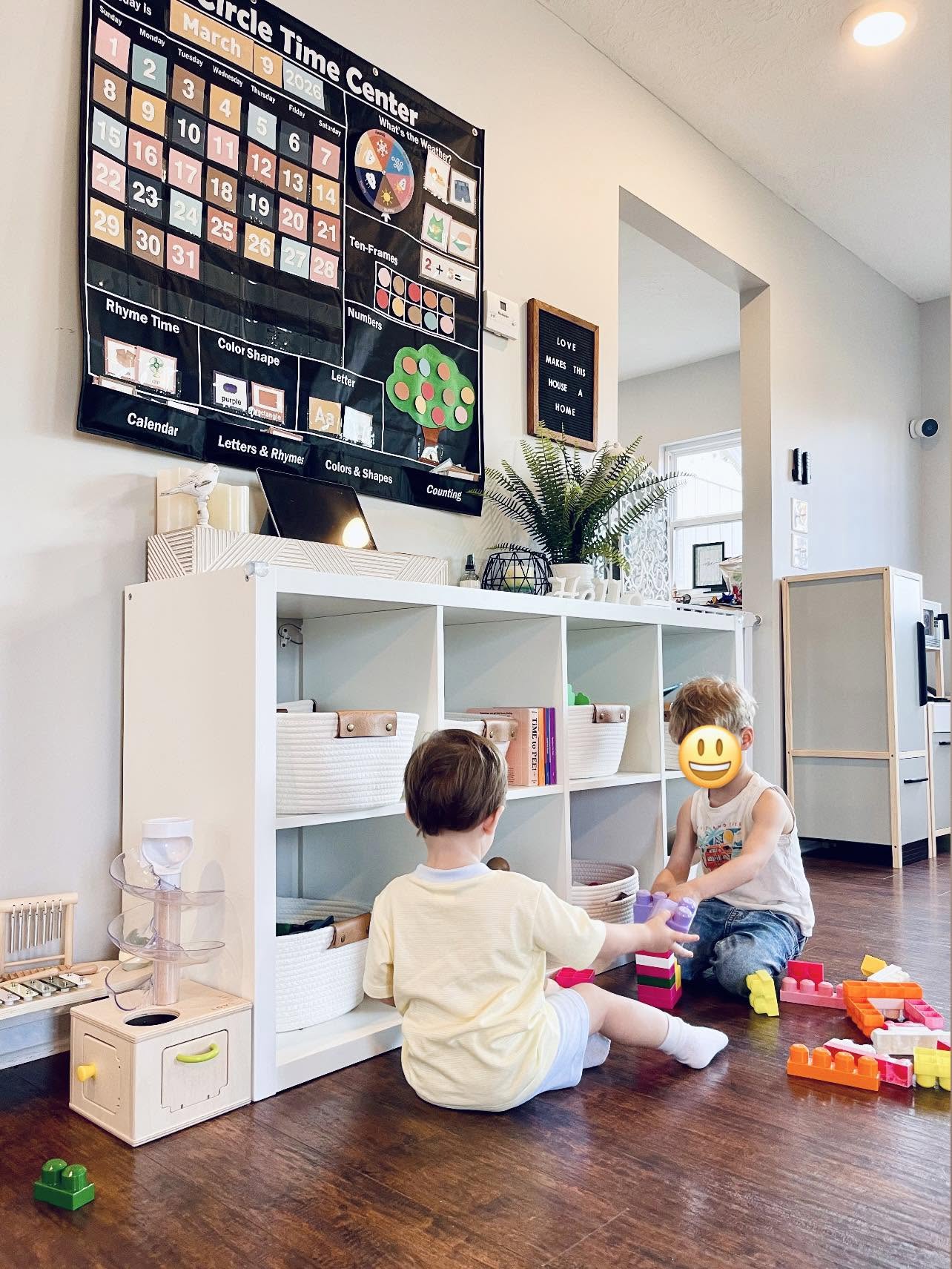Children playing with blocks beneath a circle time calendar board